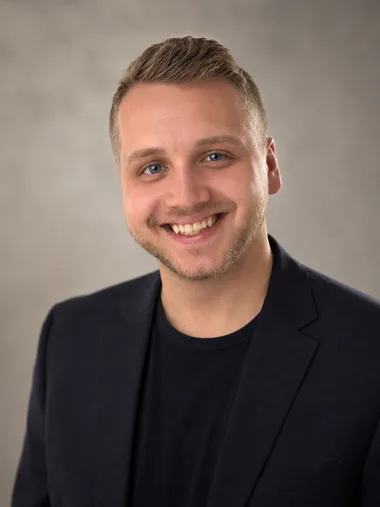 Tim Morgan, smiling, in a navy blazer
